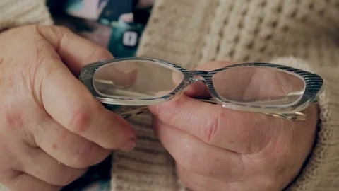 Close-up of old woman's hands holding glasses Stock Footage 74370896