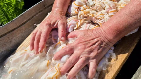 Close-up of an old woman's hands washing clothes on a washboard outdoors Video stock 196234783