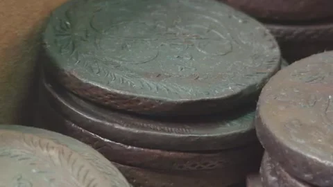 Close-up of old, worn coins stacked together, showcasing intricate designs .. Stock Footage 319433854
