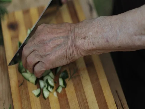 Close-up of old wrinkled hands making a fresh salad of vegetables. Stock Footage 78477491