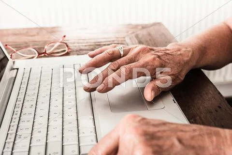 Close Up Of Older Mans Hands On Laptop