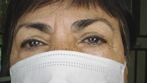 Close-up of older woman's face while wearing protective face mask Stock Footage 130544141