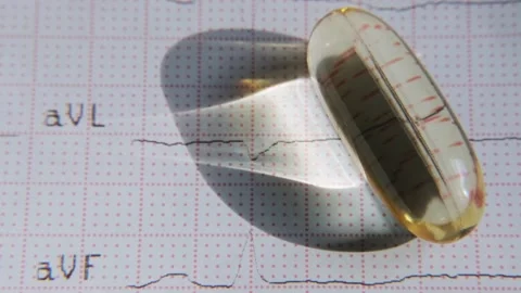 Close-up omega-3 capsule on ECG background. Healthy heart concept. Stock Footage 208002343