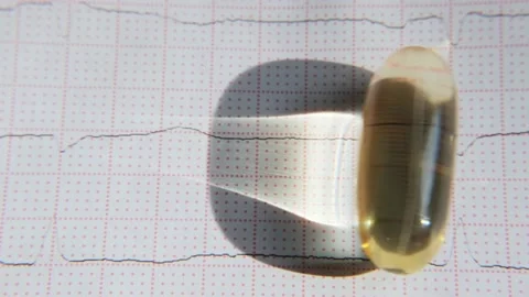 Close-up omega-3 capsule rolling on ECG background. Healthy heart concept. Stock Footage 201580671