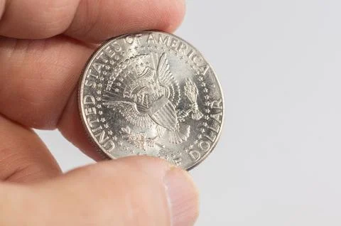 Close-up of a one-dollar coin in a hand. Stock Photos