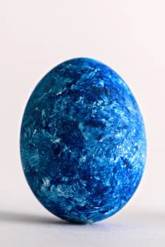 Close-up of one Easter egg in the color of the year-classic blue on white bac Stock Photos