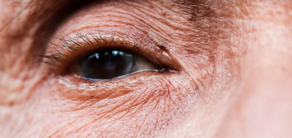 Close-up of one eye of an elderly Asian person with wrinkles around the eyes. Stock Photos