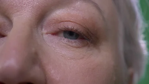 Close-up one eye portrait of elderly woman watches calmly and intently into Stock Footage 108686160