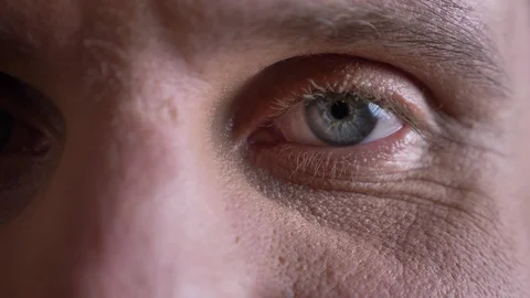Close-up one eye-portrait of middle-aged caucasian man watching calmly and Video stock 100289716
