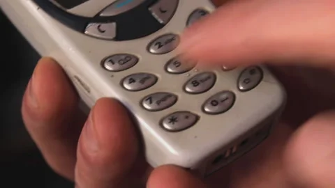 Close-up, one hand holds classic cell phone of the old generation, press buttons Stock Footage 204954741