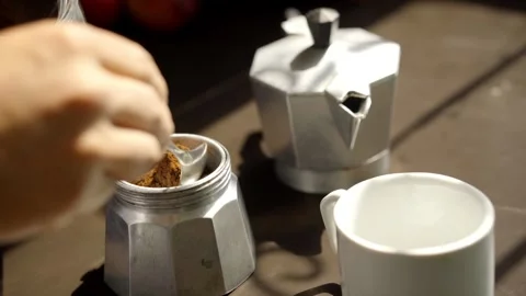 Close up of one hand placing coffee in an Italian Moka coffee maker. Stock Footage 310412111