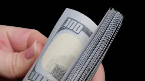 Close-up of one hundred dollar bills in the hands of a young girl Stock Footage 260484298