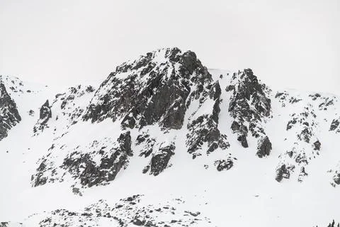 Close-up of one mountain cliff lightly dusted with snow against a clear sky 스톡 사진