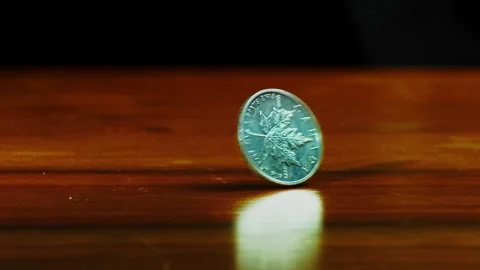 Close up of one ounce maple leaf silver coin spins on the table in slow motion Stock Footage 313633555