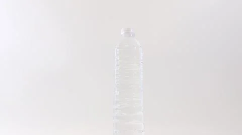 Close up one plastic bottle of drinking still water rotating over white bac.. Stock Photos