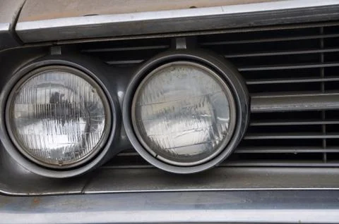 Close up of one side of double round headlights on an old classic car Stock Photos