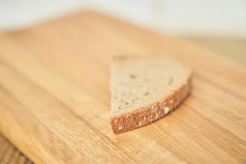 Close-up of one slice of a loaf of dark rye bread on the background of a wooden Stock Photos