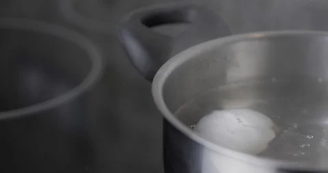 Close-Up One White Chicken Egg Hard Boiled In Stainless Pan In A Boiling Water Stock Footage 127755341