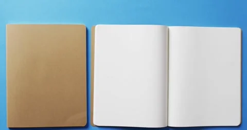 Close up of open blank book and brown notebook with copy space on blue Stock Footage 331295111