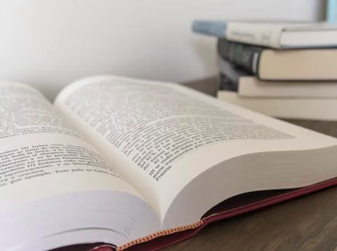 Close up of an open book and stack of books on the blurred background Stock Photos