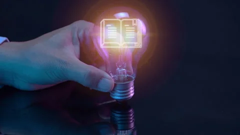 Close up of open book icon inside glowing light bulb Stock Footage 258018690