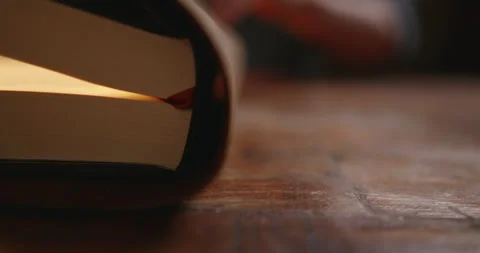 Close-Up of Open Book on Wooden Table Видео 328135588