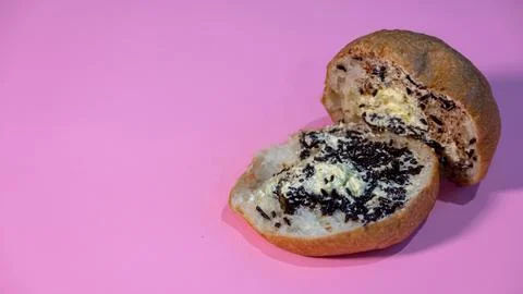 Close Up of an Open Bread Roll with Chocolate Sprinkles and Butter Filling Stock Photos