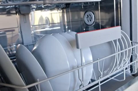 Close up open dishwasher with clean gray plates Foto stock