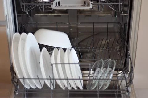 Close up open dishwasher with clean white plates Stock Photos