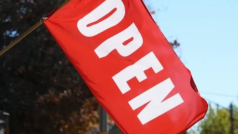 Close up of "Open" flag, in red and white, waving in the wind outside a store Stock Footage 107349378