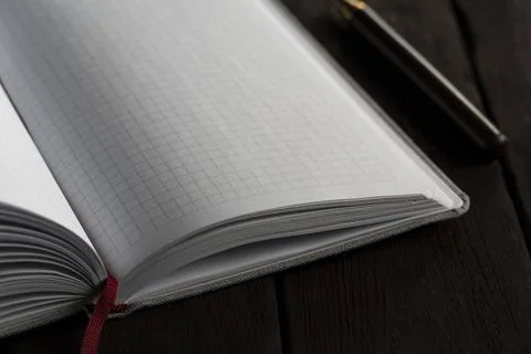 Close-Up of Open Grid Notebook on Dark Wooden Surface Stock Photos