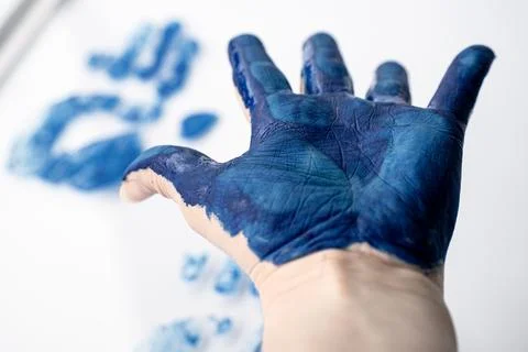 Close-up of an open hand covered in blue paint with blurred. Fotos de archivo