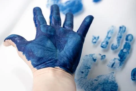 Close-up of an open hand covered in blue paint with blurred. Fotos de archivo