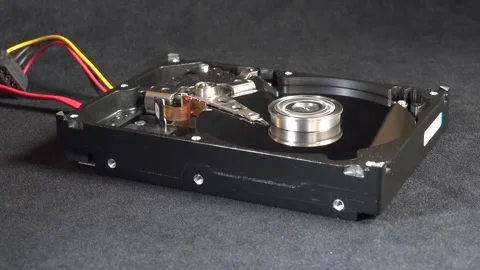 Close-up of an open hard drive with exposed internal components starting up Stock Footage 293907498