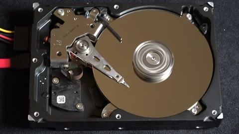Close-up of an open hard drive with spinning platter and moving reading arm Stock Footage 293904659