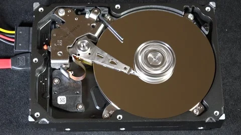 Close-up of an open hard drive with spinning platter and moving reading arm Stock Footage 293908497