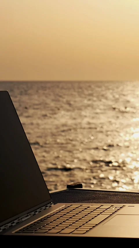 Close-up, an open laptop lies on the table in the sunlight, against the Stock Footage 323372729