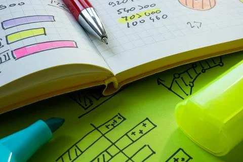 Close-up of an open notebook with financial graphs and business notes. Stock Photos