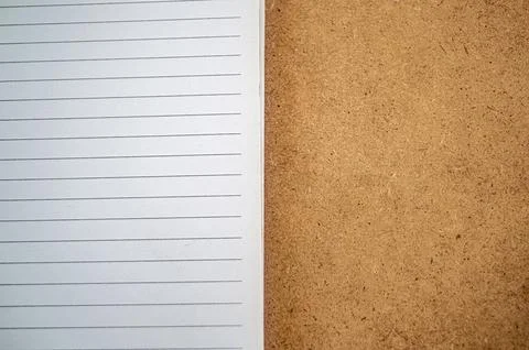 Close up of an open notebook with lined paper on the left and a textured br.. Stock Photos