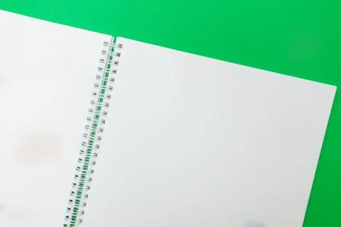 Close up of open notebook on spring lying on green background Stock Photos
