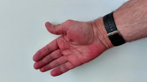 Close up of an open palm and black wrist strap over a white backdrop Video stock 329094146