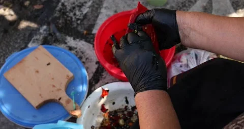 A close-up of an open, red roasted pepper full of seeds being cleaned during the 스톡 동영상 207719915