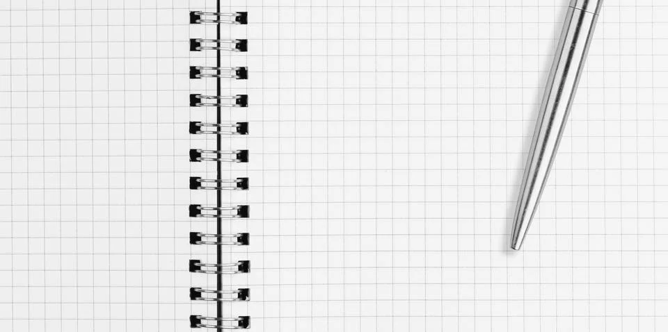 Close up of open spiral notebook graph paper page with silver metal pen Stock Photos