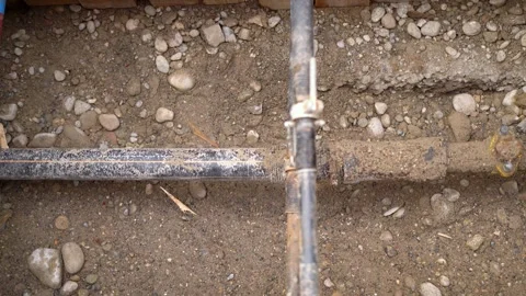 Close up of an open street construction site with metal and rubber pipe Stock Footage 263629665