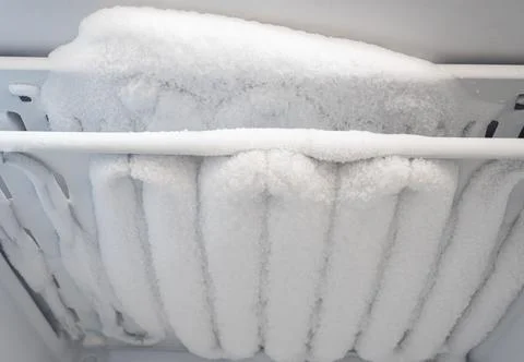Close-up of opened deep freezer with ice and snow. Freezer before defrost. Stock Photos