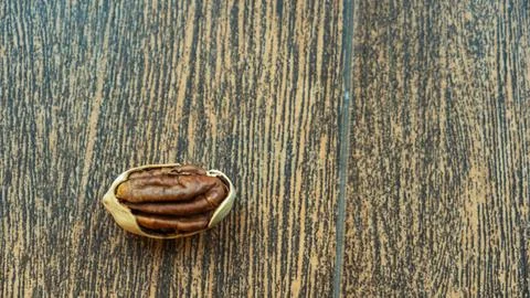 A close-up of an opened pecan nut showcases its rich texture and color agai.. Stock Photos
