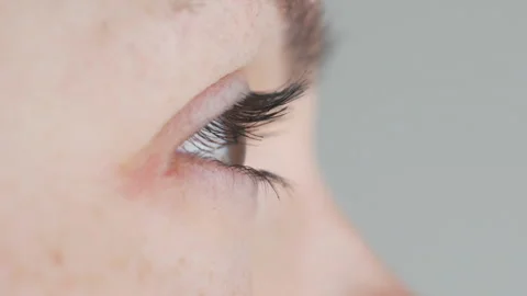 Close-up opening brown female eye. squints from the light Stock Footage 106963206