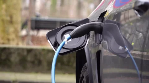 CLOSE UP: Opening charging port and plugging electric cable in, recharging the Video stock 336585532