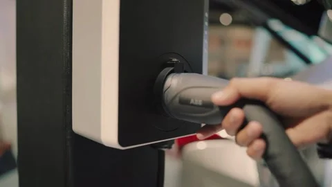 CLOSE UP: Opening charging port and plugging electric cable in, recharging the Video stock 336585579