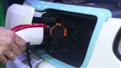 CLOSE UP: Opening charging port and plugging electric cable in, recharging the Stock Footage 336585585